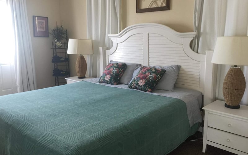 King bedroom with double doors to balcony with view of the sea